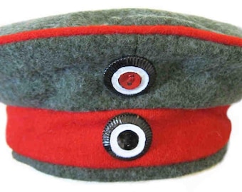 May include: A gray and red military style hat with two black and white buttons. The hat has a red band around the bottom.