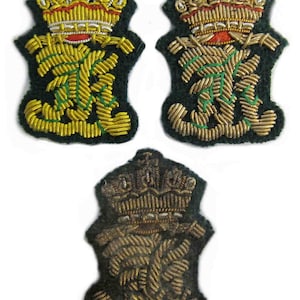 May include: Three embroidered patches with a crown design. The patches feature gold and green thread detailing on a dark green background. The crowns have red and gold accents. The bottom patch is a darker, more muted colour.