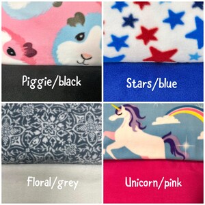 May include: A four-panel collage of fleece fabric swatches. Top left: pink and blue guinea pig print with black fabric. Top right: white fabric with red and blue stars over solid blue. Bottom left: grey floral pattern over white. Bottom right: unicorn and rainbow print over solid pink.
