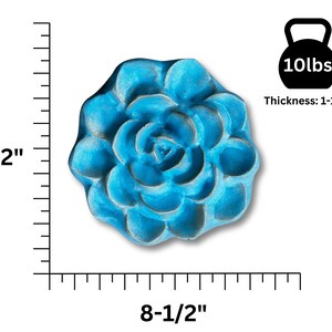 May include: A turquoise, flower-shaped decorative object. It measures 8.5 inches in diameter and 1.25 inches thick, and weighs 10 lbs. The object has a detailed, textured surface, and is designed to resemble a blooming flower.