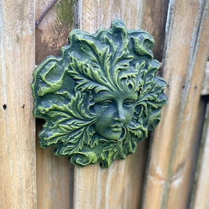 Green lady concrete face plaque with embedded hanger green woman face statue