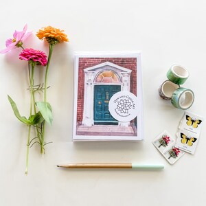 May include: A watercolor painting of a green door with a brick archway and a red brick building. The painting is on a white card with a sticker that says "Hen and Chick Art".