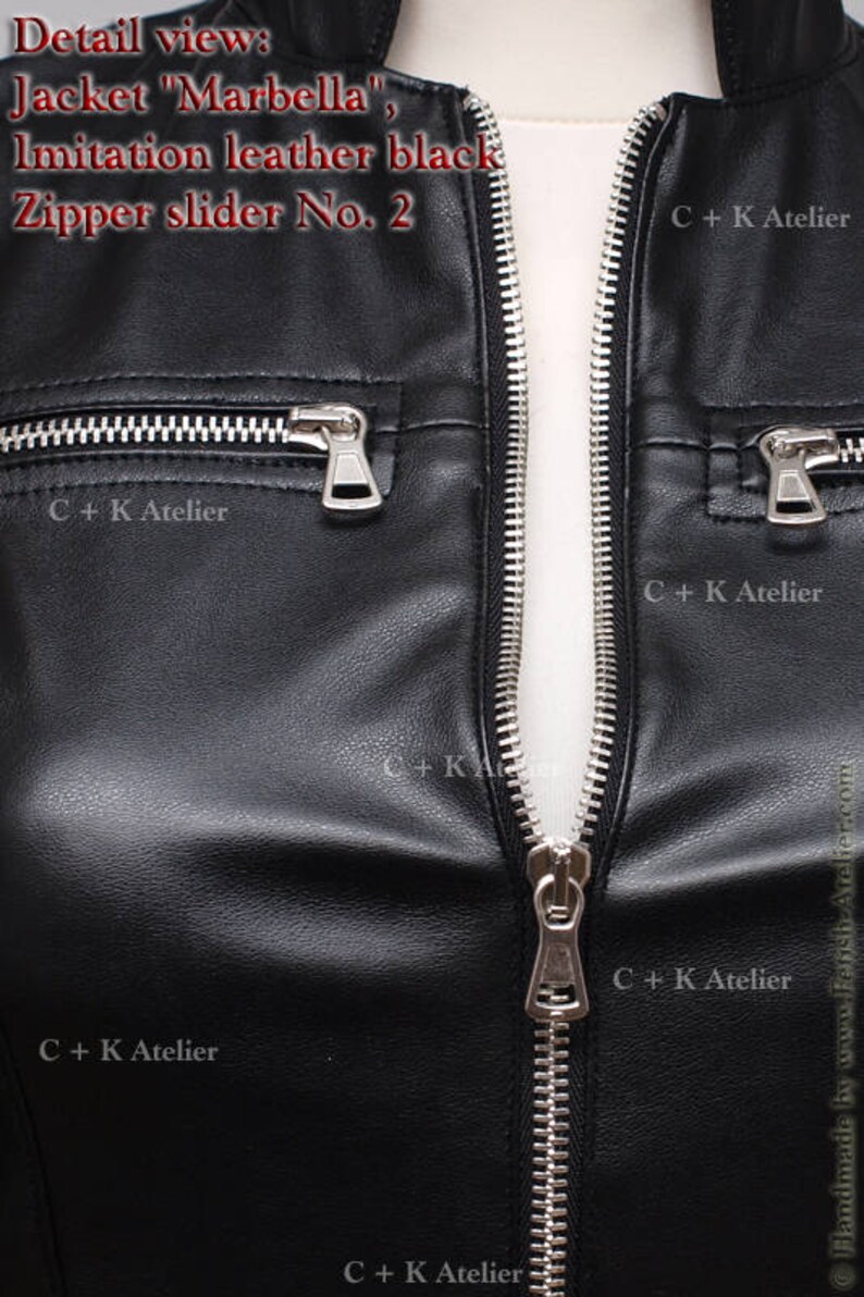 May include: Close-up of a black leather jacket zipper with a silver slider. The zipper is partially open, revealing the white lining of the jacket. The text "C+K Atelier" is visible on the jacket.