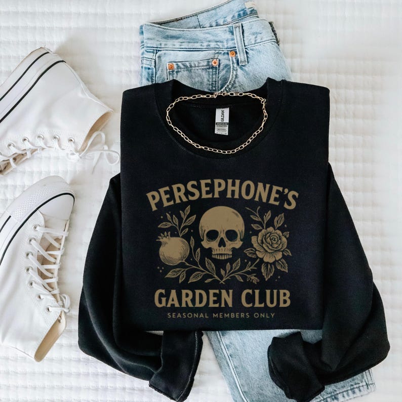Sweatshirt featuring skull, pomegranate, and floral elements with text “Persephone’s Garden Club
