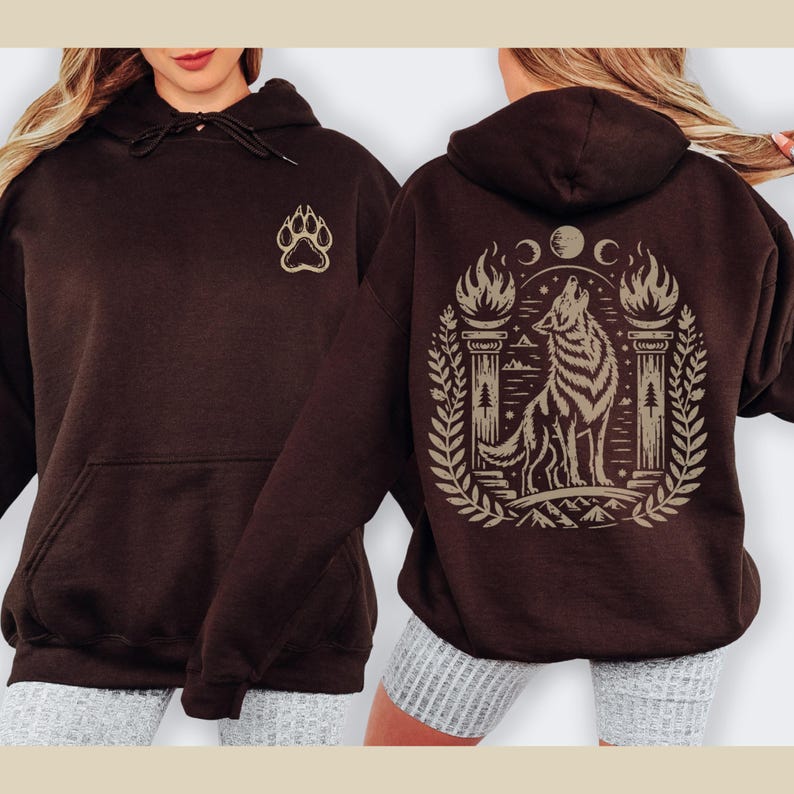 Hoodie with beige howling wolf and triple moon design. Navy hoodie with same design. Maroon hoodie with back wolf design and small front paw print. Black and dark chocolate hoodies shown on models, with front and back views.