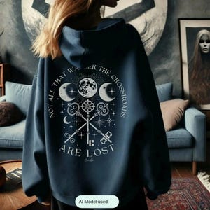 Embrace the power of Hecate with our Crossroads Hoodie. This divine feminine design honors the Moon Goddess and her symbolism of the crossroads, perfect for those who believe 'Not All Who Wander the Crossroads Are Lost