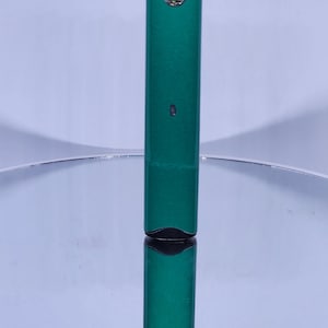 May include: A green and black electronic cigarette with a rectangular shape.