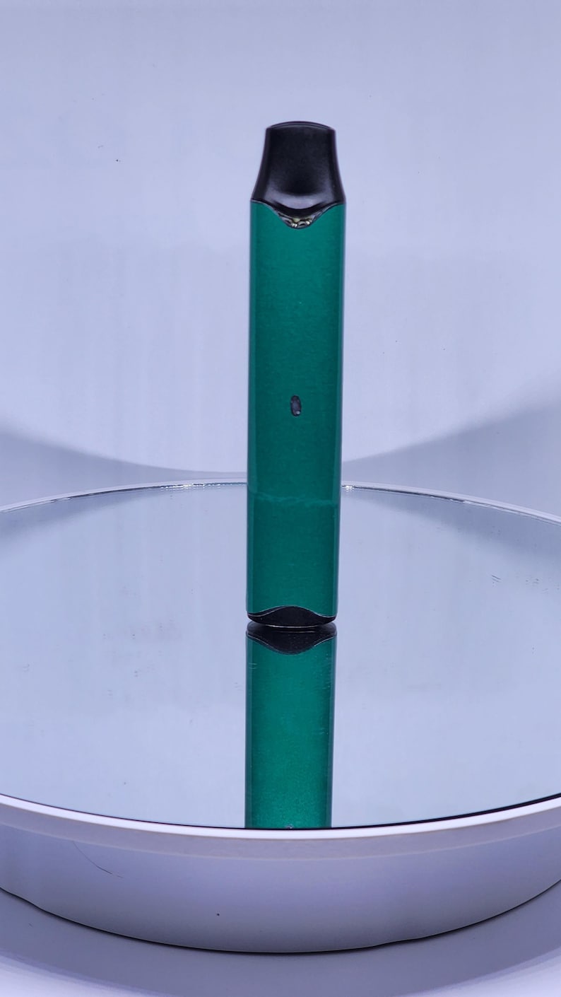 May include: A green and black electronic cigarette with a rectangular shape.