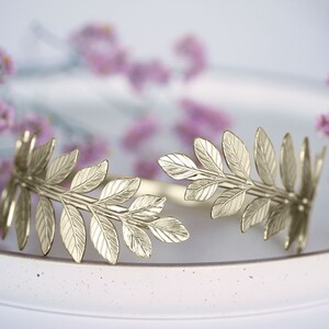 May include: Gold leaf wreath with a delicate design, perfect for adding a touch of elegance to any occasion.