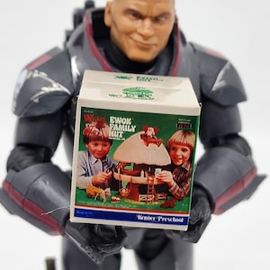 May include: A vintage Kenner Preschool Ewok Family Hut playset box with a brown and white treehouse, two children, and a white pony. The box is white with green and red accents. The text on the box reads "Ewok Family Hut Preschool Toy Kenner Preschool".