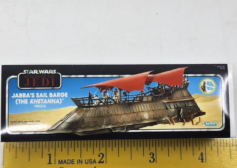 May include: A Star Wars Return of the Jedi box for Jabba's Sail Barge (The Khetanna) vehicle. The box features a colourful image of the sail barge with red sails and a desert background. The text "Kenner" is visible in the bottom right corner.
