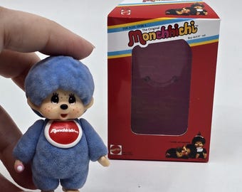 Miniatura del mono azul Monchhichi más pequeño del mundo con mini caja personalizada. La figura cabe dentro.