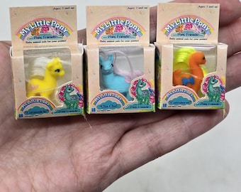 May include: Three small My Little Pony toy boxes with baby animal pals for your ponies. The boxes are yellow, blue, and orange with a rainbow design. The boxes are labeled "Creamsicle", "Cha Cha", and "Cutesaurus".