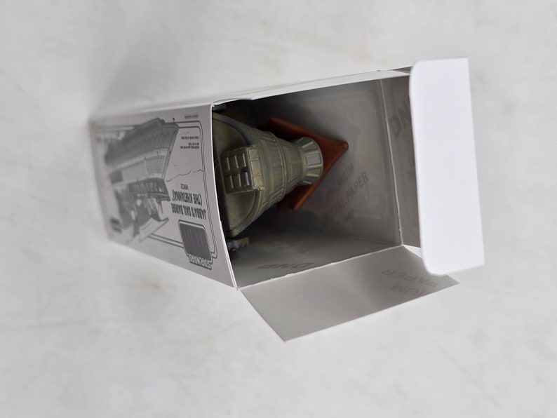 May include: A white box with a grey and green model spaceship inside. The box has a picture of the spaceship on the side and the text "Limited Edition 1:100 Scale Model of the Starship Enterprise".
