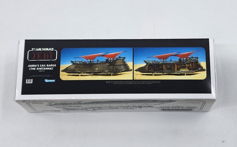May include: A white box with a red and black Star Wars: Return of the Jedi logo. The box features a picture of Jabba's Sail Barge (The Khetanna) with red sails. The text "Jabba's Sail Barge (The Khetanna)" is printed on the box.