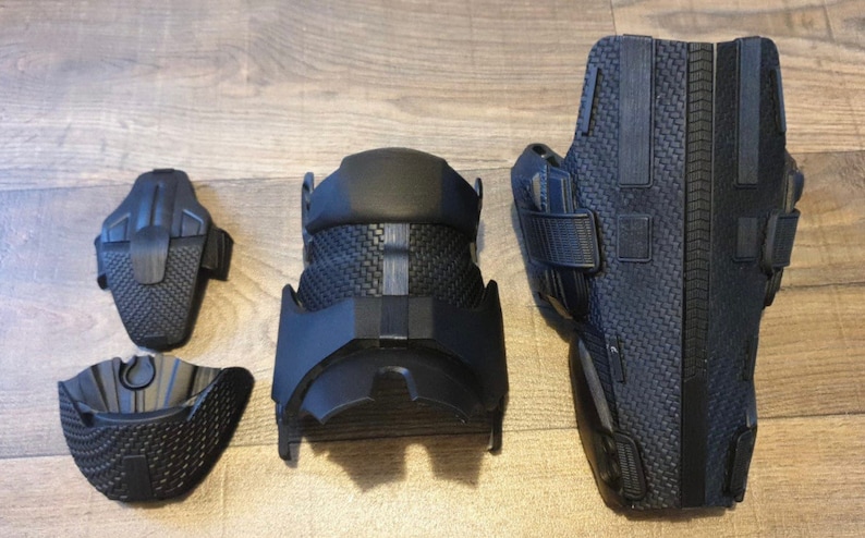May include: Four black knee pads with a textured surface and straps. The knee pads are designed for protection and support.