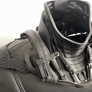 May include: Black plastic neck and shoulder armor with a textured surface and multiple adjustable straps.