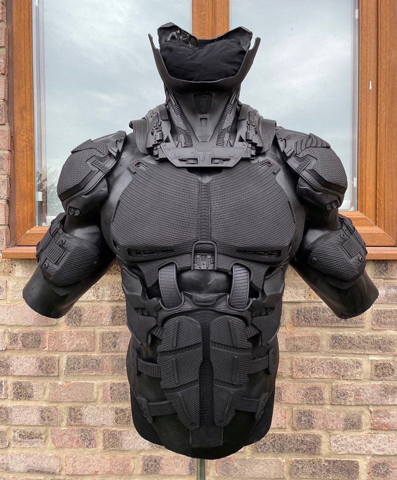 May include: Black and gray detailed plastic armor for cosplay or costume. The armor is designed to look like a futuristic or sci-fi suit.