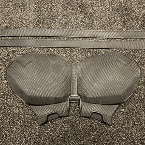 May include: A black foam chest piece with a textured surface. The chest piece is designed to look like a superhero's chest plate.