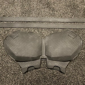 May include: A black foam chest piece with a textured surface. The chest piece is designed to look like a superhero's chest plate.