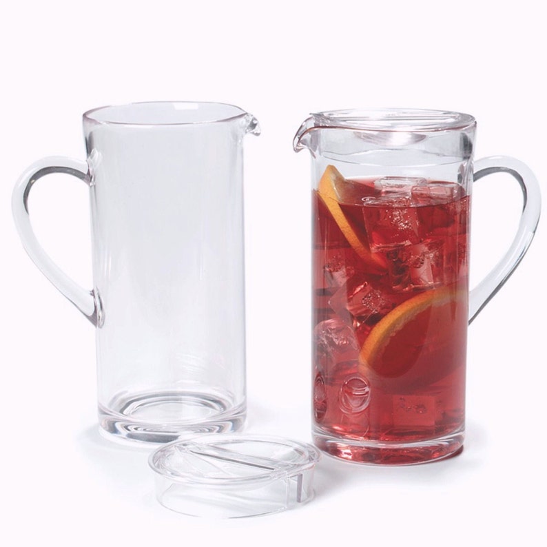 Puede incluir: Dos jarras de pl&aacute;stico transparente, una llena de l&iacute;quido rojo, cubitos de hielo y rodajas de naranja. La jarra de la derecha tiene una tapa.
