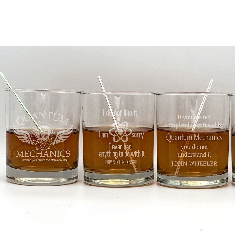 May include: Three clear glass tumblers with engraved quotes about quantum mechanics. The first tumbler says "QUANTUM MECHANICS E=MC2 Tweaking your reality one atom at a time." The second tumbler says "I do not like it, and I am sorry I ever had anything to do with it. ERWIN SCHR&Ouml;DINGER." The third tumbler says "If you are not completely confused by Quantum Mechanics you do not understand it. JOHN WHEELER."