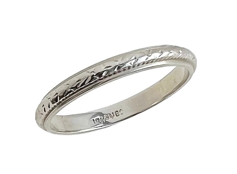Pode incluir: Uma alian&ccedil;a de casamento simples, de prata, com um design texturizado. A alian&ccedil;a &eacute; marcada com "14K" no interior.