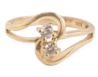 May include: A gold ring with two small diamonds set in a heart shape. The ring is marked "10K" on the inside.