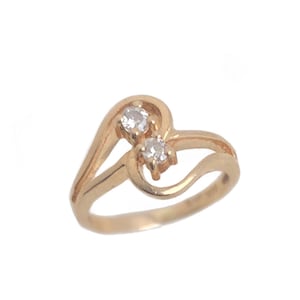 May include: A gold ring with two clear stones set in a heart-shaped design.
