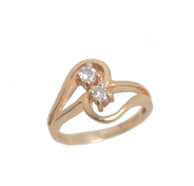 May include: A gold ring with two clear stones set in a heart-shaped design.