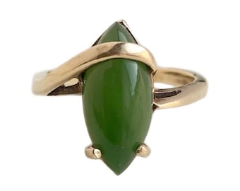 May include: A gold ring with a marquise-shaped green jade stone set in a twisted band.