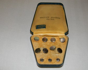 May include: A green and gold box with the text "Wallach Brothers New York" and "Larter Jewelry" inside. The box contains eight silver cufflinks with mother-of-pearl inlays.
