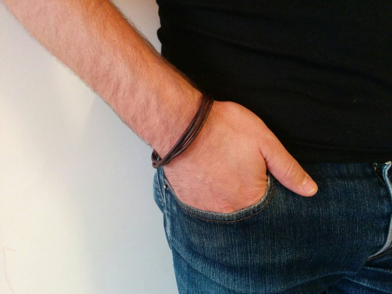 May include: A brown leather bracelet with multiple strands wrapped around a wrist.