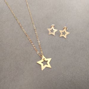 May include: A gold necklace with a star pendant and a pair of matching star earrings.