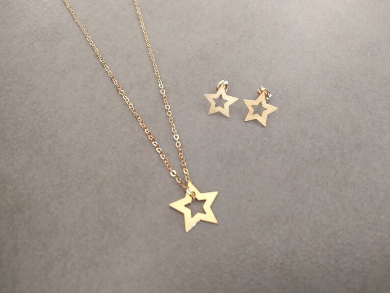 May include: A gold necklace with a star pendant and a pair of matching star earrings.