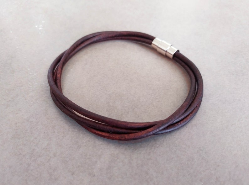 May include: A brown leather bracelet with a silver magnetic clasp.