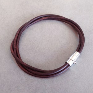 May include: A brown leather bracelet with a silver magnetic clasp.