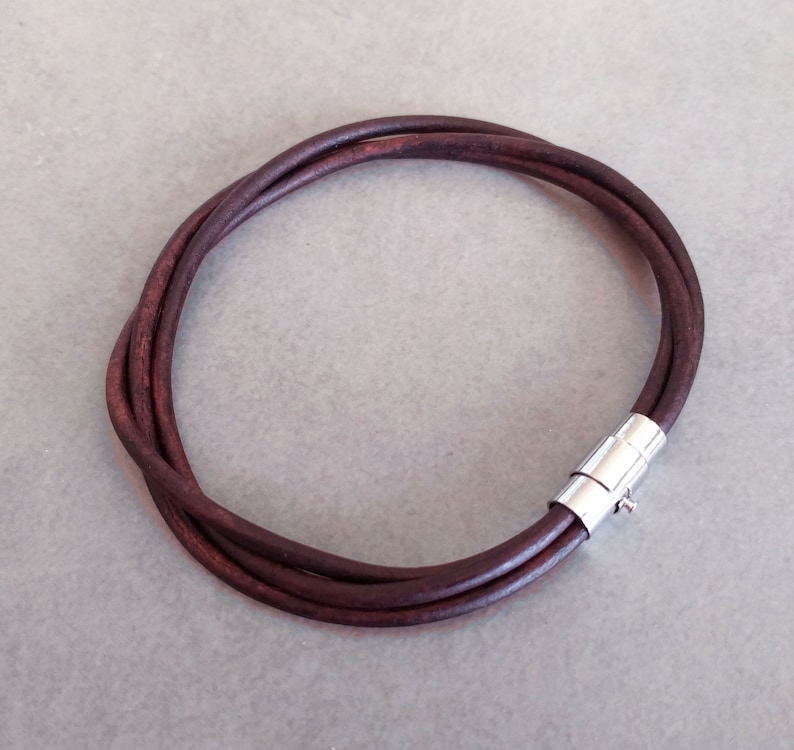 May include: A brown leather bracelet with a silver magnetic clasp.
