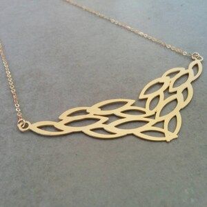 May include: A gold necklace featuring a delicate chain and a pendant crafted from interlinked leaf shapes.
