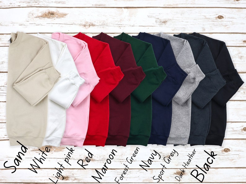 May include: Ten crewneck sweatshirts in various colors, including sand, white, light pink, red, maroon, forest green, navy, sport grey, dark heather, and black.