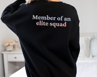 May include: Black sweatshirt with the text "Member of an elite squad" printed on the back in white with red and blue accents.