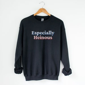 May include: Black sweatshirt with the text "Especially Heinous" in white letters with red and blue accents.