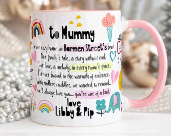 Può includere: Una tazza in ceramica bianca con un manico rosa. La tazza ha un design colorato con arcobaleni, cuori e un elefante. Il testo sulla tazza dice "to Mummy" e "love Libby & Pip".