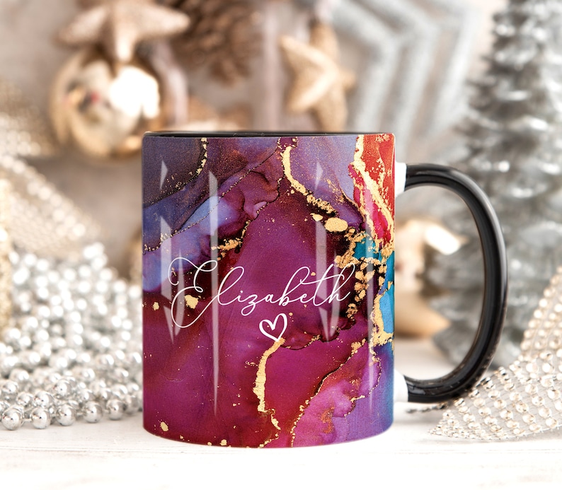 May include: A black coffee mug with a white handle. The mug has a colorful abstract design with gold accents and the name "Elizabeth" written in white with a small heart.