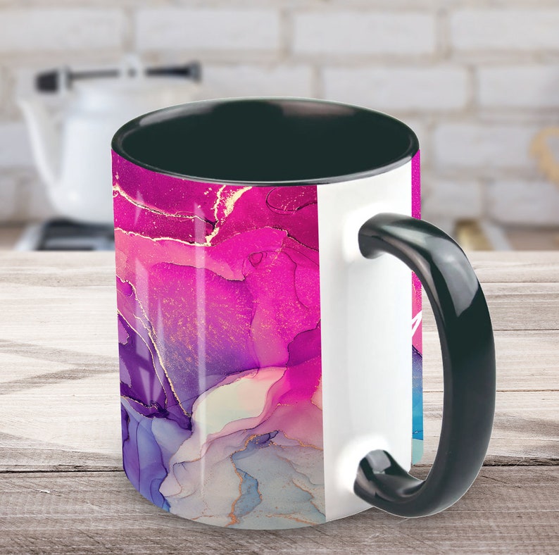 Pu&ograve; includere: Una tazza da caff&egrave; bianca e nera con un design astratto rosa, viola e oro. La tazza ha un manico nero e un interno nero.
