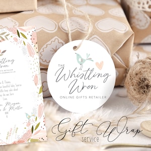 May include: A white round gift tag featuring a light blue bird and pink heart design. The text "The Whistling Wren Online Gifts Retailer" is printed on the tag.