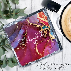 May include: A square, dark gray slate coaster with a colorful abstract design in shades of purple, blue, red, and gold. The name "Elizabeth" is written in white cursive with a small heart symbol.