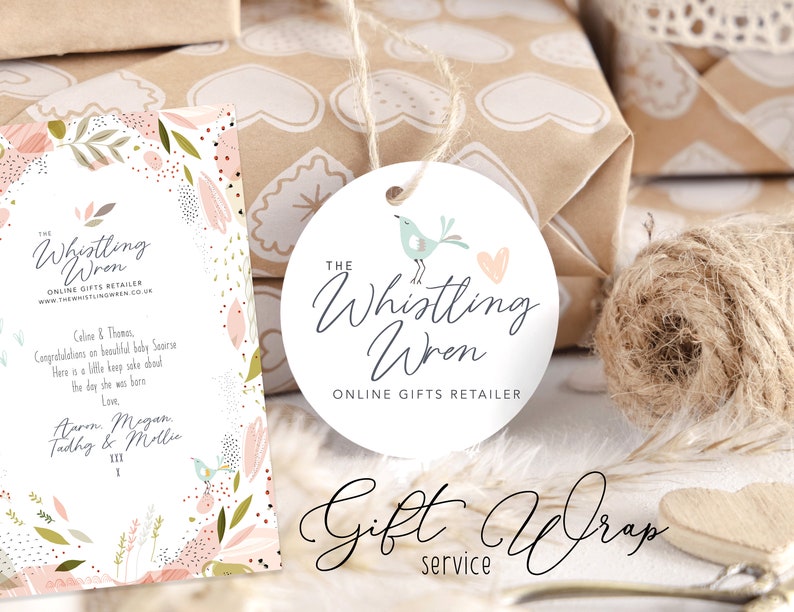 May include: A white round gift tag with a light blue bird and pink heart design. The text "The Whistling Wren Online Gifts Retailer" is printed on the tag.