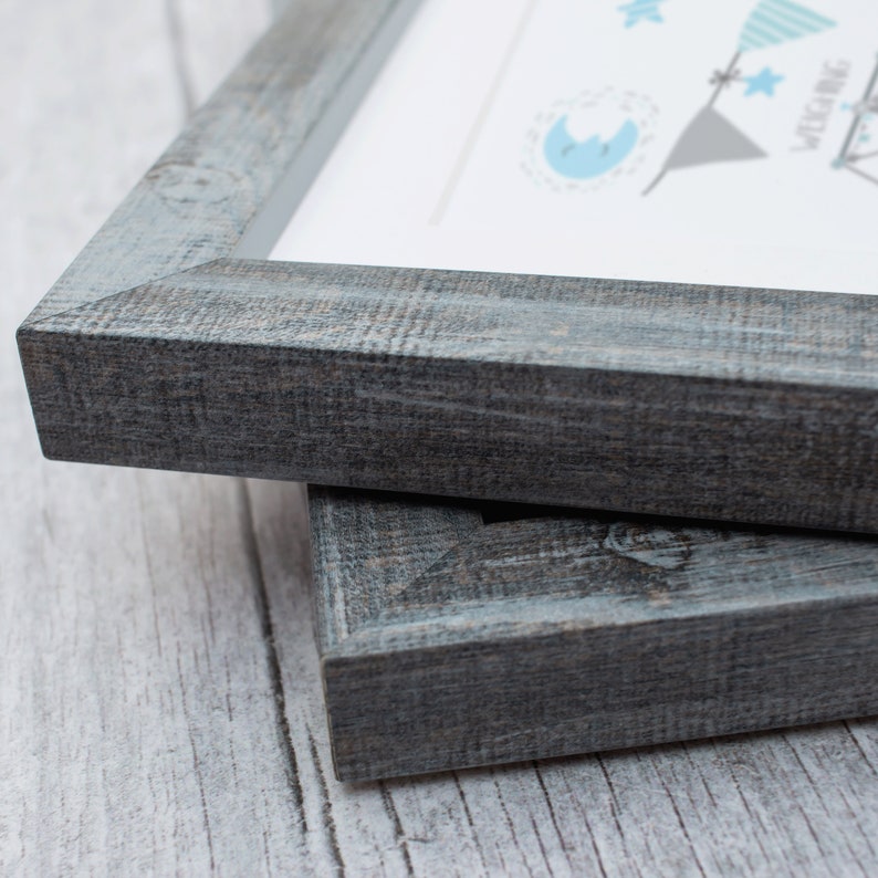 May include: Two gray wooden picture frames stacked on top of each other. The frames have a rustic, distressed look.