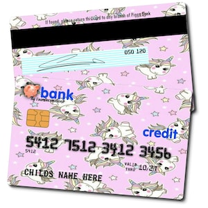 May include: A pink credit card with a unicorn pattern. The card has the text "credit" and "5412 7512 3412 3456" printed on it. The card also has the text "VALID THRU 10/21" printed on it.
